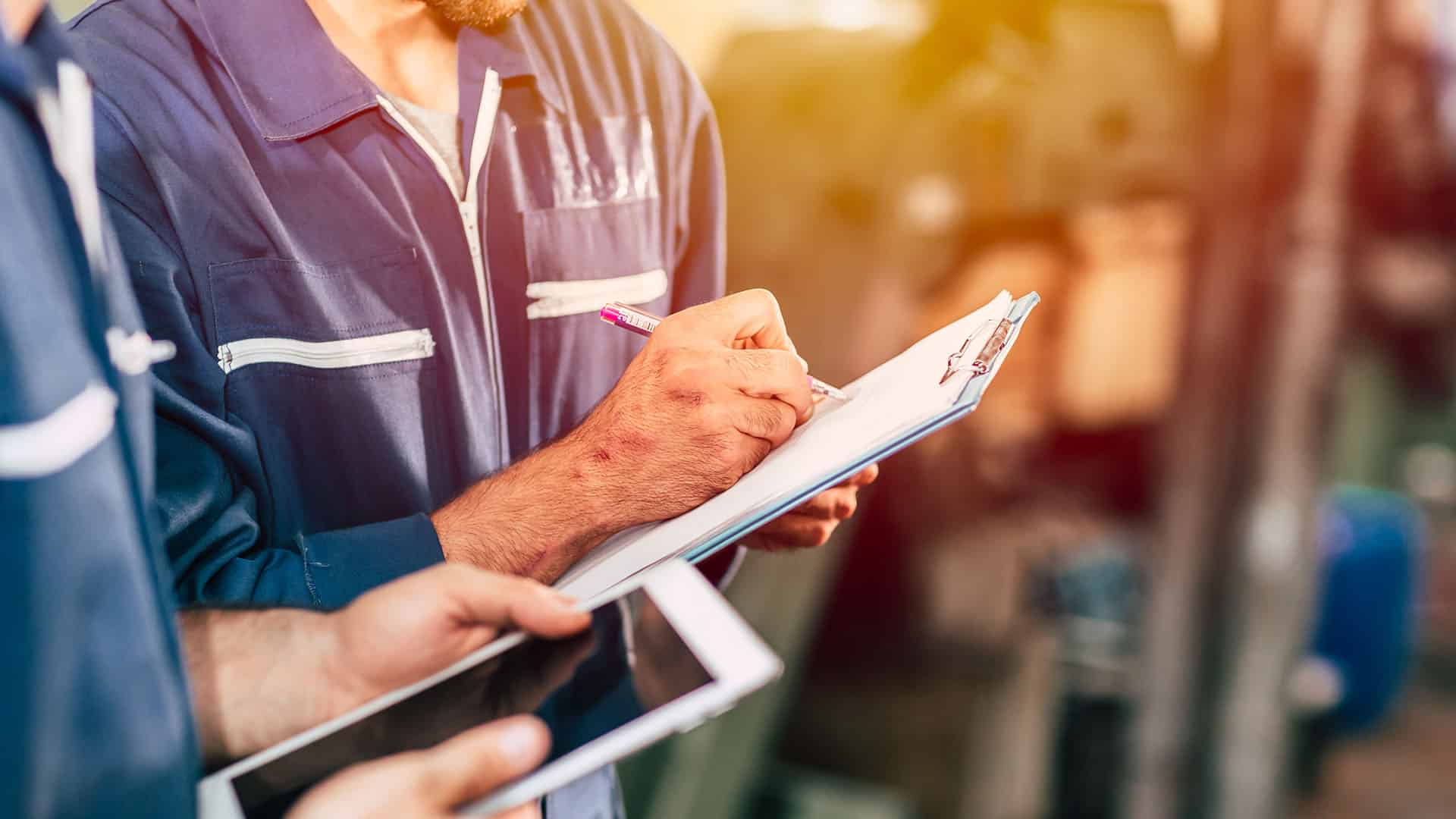 worker taking note using pen and paper