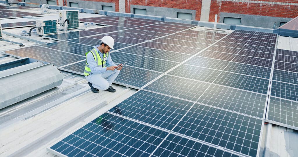 Inspection, man and tablet for solar panels, energy saving and electricity or heating of eco friendly grid on rooftop. Engineering, digital technology and photovoltaic technician for installation